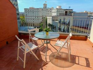 um pátio com uma mesa e cadeiras numa varanda em By Paseo de Colón Apartment em Barcelona