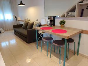 a kitchen and living room with a table and stools at By Paseo de Colón Apartment in Barcelona