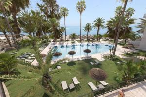 an overhead view of a pool with chairs and umbrellas at Hotel Best Triton in Benalmádena