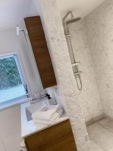 uma casa de banho com um chuveiro e um lavatório com toalhas em Duinstudio Bergen em Bergen