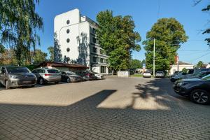 un estacionamiento con autos estacionados frente a un edificio en Rija VEF Hotel with FREE Parking en Riga