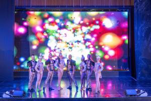 Un grupo de bailarines en un escenario frente a una pantalla. en Serenade Punta Cana Beach & Spa Resort, en Punta Cana