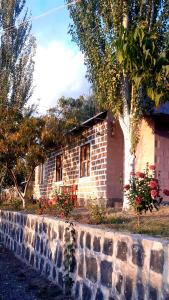 uma casa de tijolos com uma árvore e uma parede de tijolos em GreenField GH em Yeghegnadzor