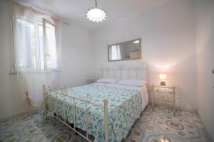 Schlafzimmer mit einem Bett und einem Wandspiegel in der Unterkunft Agriturismo Le Tagliate in Uggiano la Chiesa