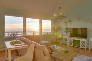 a living room with a couch and a table with a television at Oceanfront Kenai Villa with Fireplace and Deck in Kenai