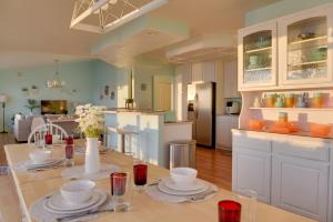 a kitchen with a table with plates and flowers on it at Oceanfront Kenai Villa with Fireplace and Deck in Kenai