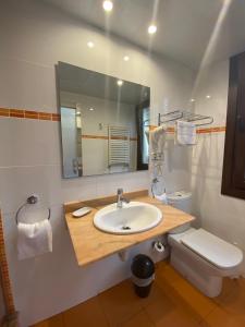 a bathroom with a sink and a toilet and a mirror at Hotel Cantón in Barcelona