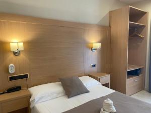 um quarto com uma cama branca e uma cabeceira em madeira em Hotel Cantón em Barcelona