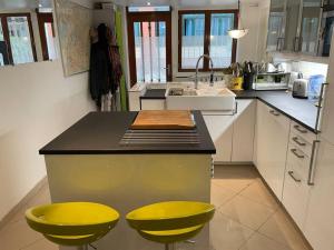 uma cozinha com dois bancos amarelos num balcão em Appartement de 90m² en souplex em Paris