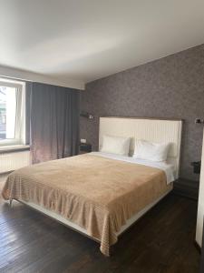 een slaapkamer met een groot bed met witte kussens bij Afina Aparthotel in Odessa