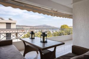 d'une table et de chaises sur un balcon avec vue. dans l'établissement Athenian Riviera Executive Apartment, à Vari