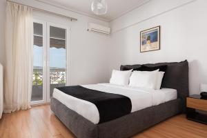 - une chambre avec un grand lit et une fenêtre dans l'établissement Athenian Riviera Executive Apartment, à Vari