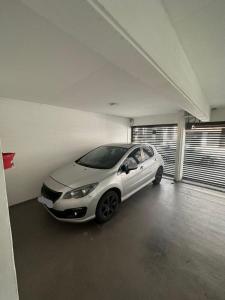 a white car is parked in a garage at Apartamento 2 habitaciones Pichincha in Rosario