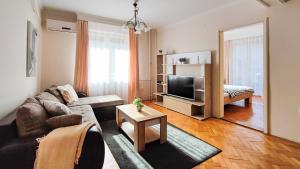 un soggiorno con divano e TV di FilinHome Jaksica Suite a Novi Sad