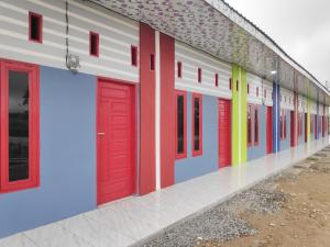 uma fila de portas coloridas num edifício em RedDoorz @ Jalan Ujung Aji Berastagi em Berastagi