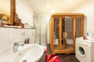 a bathroom with a sink and a washing machine at Fuchswiese in Thurmansbang +14 photos
