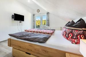 1 dormitorio con 1 cama y TV en la pared en Fuchswiese, en Thurmansbang