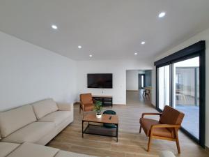 - un salon avec un canapé, des chaises et une télévision dans l'établissement Abu Dhabi, magnifique maison, à Reims