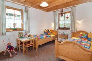 - une chambre avec 2 lits, un bureau et une table dans l'établissement Ponyhof Killinger, à Zwiesel