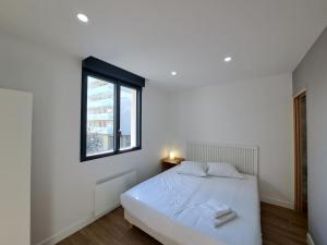 - une chambre blanche avec un lit et une fenêtre dans l'établissement Abu Dhabi, magnifique maison, à Reims