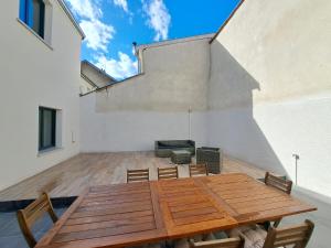 Une table et des chaises en bois sont disponibles sur la terrasse. dans l'établissement Abu Dhabi, magnifique maison, à Reims