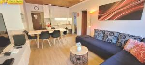 - un salon avec un canapé bleu et une table dans l'établissement Apartment Almkogel by FiS - Fun in Styria, à Tauplitz