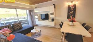 - un salon avec un canapé, une table et une télévision dans l'établissement Apartment Almkogel by FiS - Fun in Styria, à Tauplitz