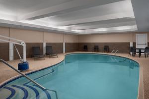 a pool in a hotel room with chairs and tables at Residence Inn Boston Dedham in Dedham