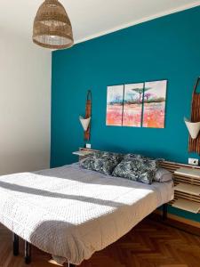 een slaapkamer met een blauwe muur en een bed bij Bilocale di charme in centro in Parma