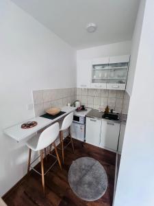 a kitchen with white cabinets and a table and chairs at Golden joy in Sarajevo +8 photos