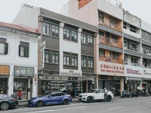 uma rua com carros estacionados em frente aos edifícios em Noble Hotel Express, Check in 10PM, Check out 9AM em Singapura