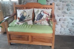 een houten stoel met twee kussens erop bij Cabanas Armonia in Cotundo