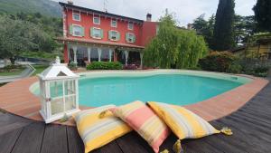 - une piscine avec une lanterne et des oreillers à côté d'une maison dans l'établissement B&B POGGIO CAIAR, à Caprino Veronese