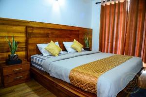 a bedroom with a large bed with a wooden headboard at Kapri Luxury Apartment in Nuwara Eliya