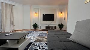 a living room with a couch and a flat screen tv at Charming Apartment in 6th October Cairo Giza Family Only in 6th Of October