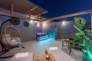 een terras met stoelen en een zwembad bij Hersonissos Beach Front Suites in Chersonissos