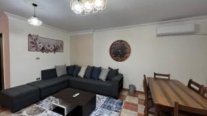 uma sala de estar com um sofá preto e uma mesa em Charming Apartment in 6th October Cairo Giza Family Only em Cidade 6 de Outubro