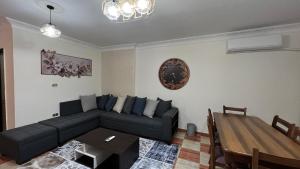 a living room with a black couch and a table at Charming Apartment in 6th October Cairo Giza Family Only in 6th Of October