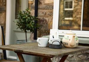 una mesa de madera con tazas y tazas. en Maesgwyn, en Pembrokeshire