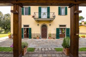 ein Haus mit grünen Rollläden und einem Balkon in der Unterkunft Agriturismo LaPievuccia in Castiglion Fiorentino