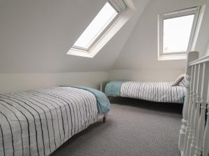 two beds in a room with two windows at 11a Manning Road in Felixstowe