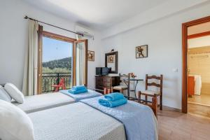 1 dormitorio con 2 camas y balcón en Villa Christina near Stafylos beach, en Skopelos Town