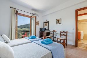 a bedroom with two beds and a balcony at Villa Christina near Stafylos beach in Skopelos Town