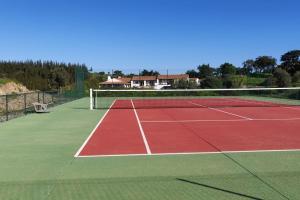 um campo de ténis com uma rede por cima em Monte da Pereirinha a country house with pool and tennis court, 20 mins from beaches em São Bartolomeu da Serra