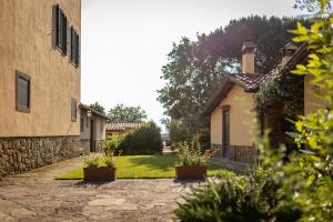 einen Steinweg zwischen zwei Gebäuden mit Topfpflanzen in der Unterkunft Agriturismo LaPievuccia in Castiglion Fiorentino