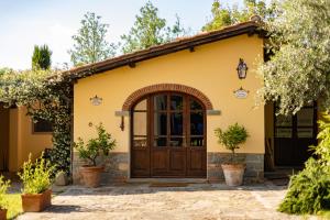 a house with a wooden door in a yard at Agriturismo LaPievuccia in Castiglion Fiorentino