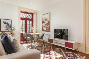 - un salon avec un canapé, une télévision et une table dans l'établissement Apartments2Stay I Porto - Flores, à Porto