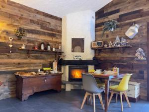 a dining room with a table and a fireplace at Bed and Breakfast Campo Base in Carona