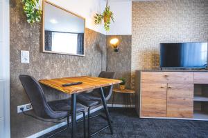 Cette chambre dispose d'une télévision et d'une table avec des chaises. dans l'établissement Golden Nugget - Wohnungen und Apartments der besondern Art!, à Bünde