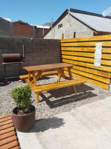 a wooden picnic table sitting next to a fence at Tem Kotenkesh Depto Telenken x 2 pax in El Calafate